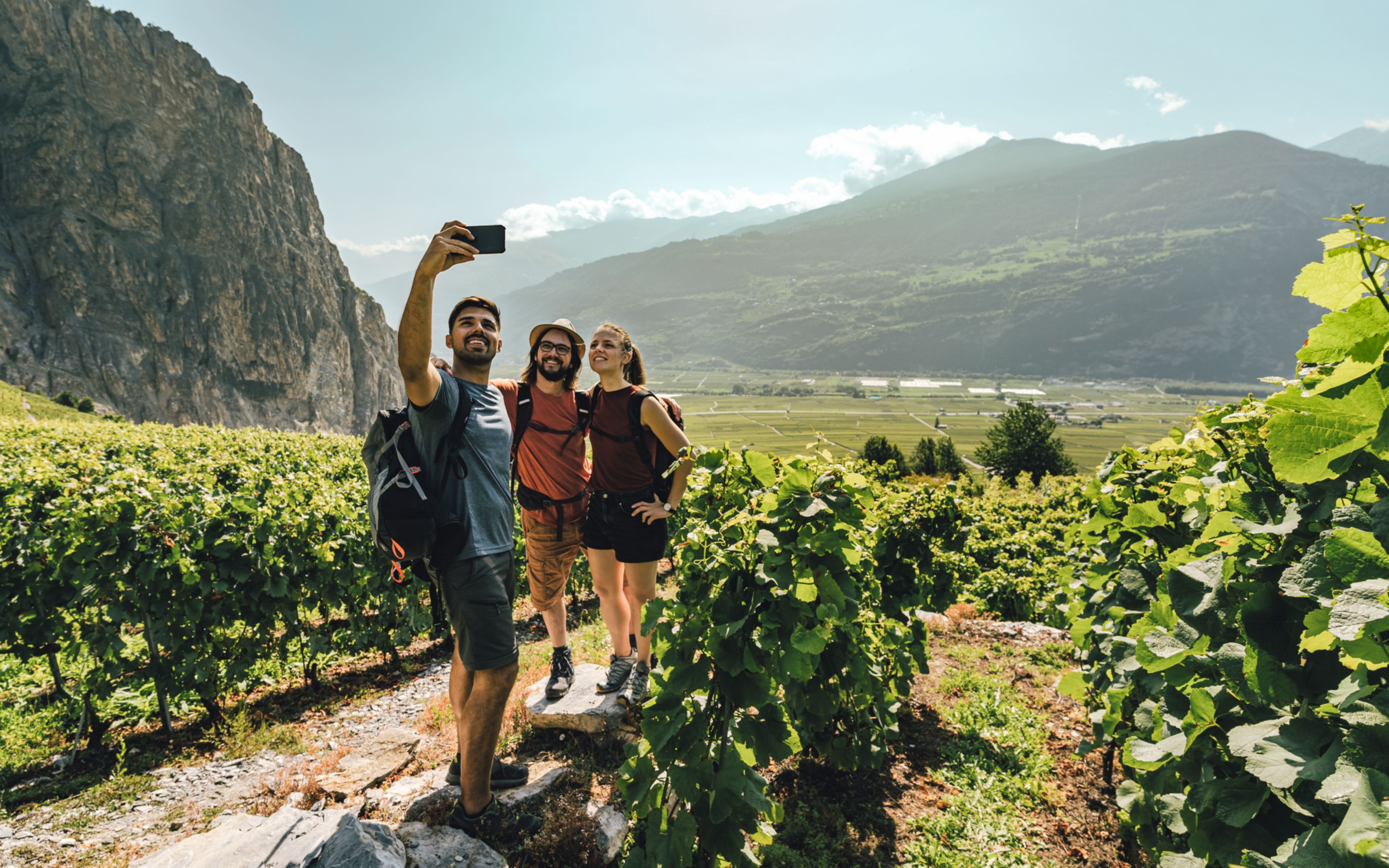 3 adults take a picture selfie in the vineyard of Chamoson, Valais, Switzerland