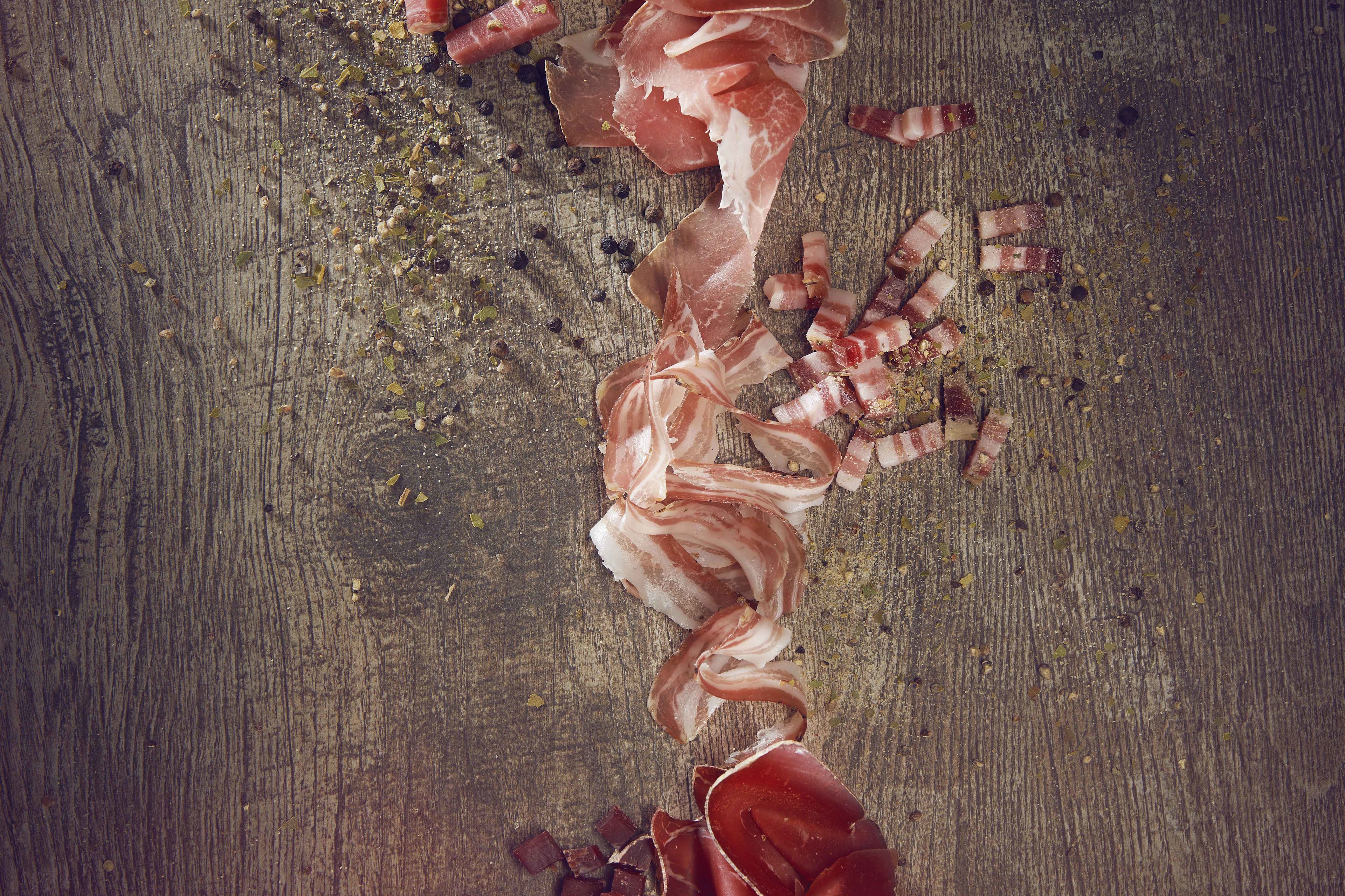 Walliser Trockenfleisch (Trockenfleisch, trockener Speck und Rohschinken) auf einem Holztisch, Valais Wallis Schweiz Suisse