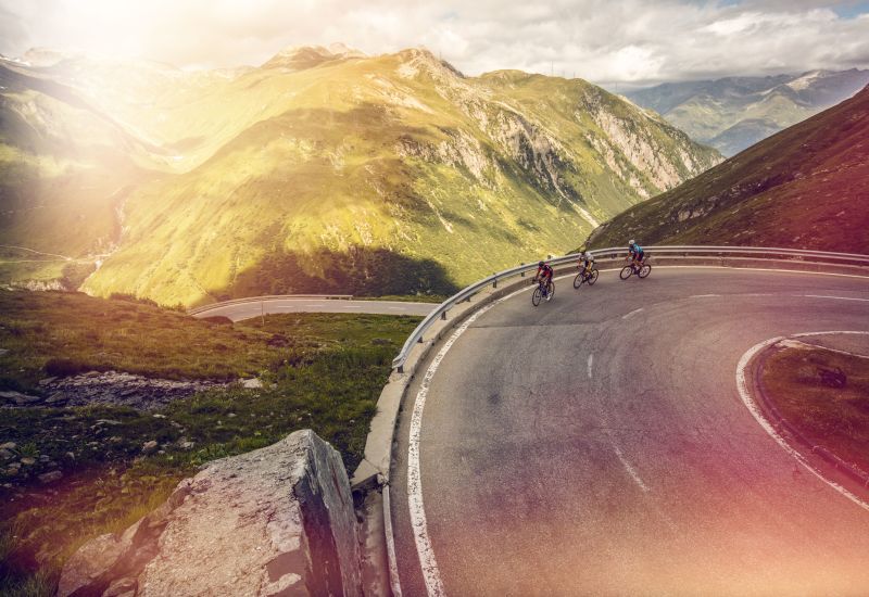 3 Cyclistes sur la montée du Nufenen. Valais Suisse