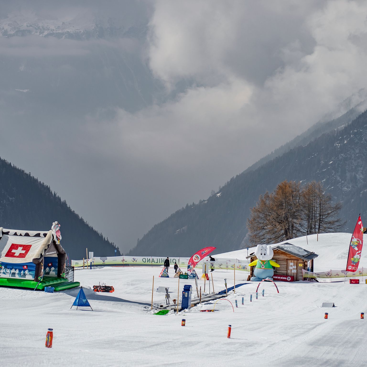 Kinderbereich „Loichi-Land“ mit Fahnen, Figuren und Übungsgelände im Schnee