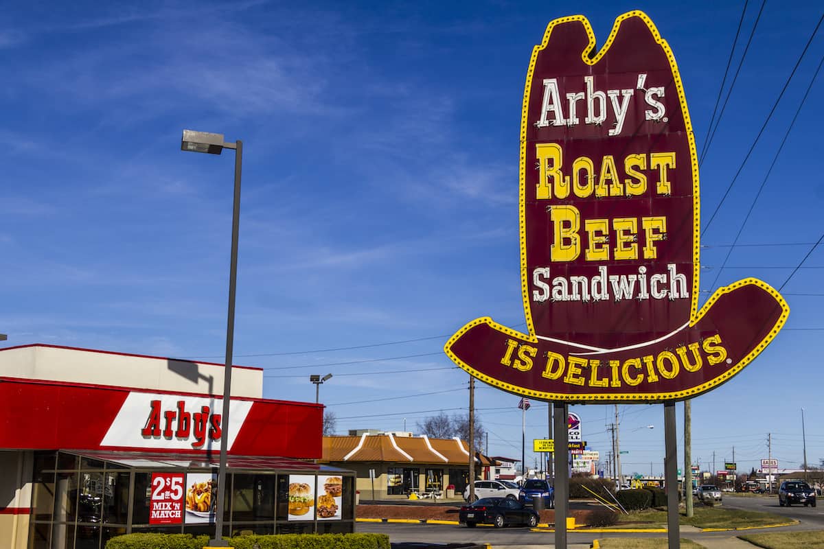 An outdoor sign next to an Arby's restaurant promoting Arby's roast beef sandwich