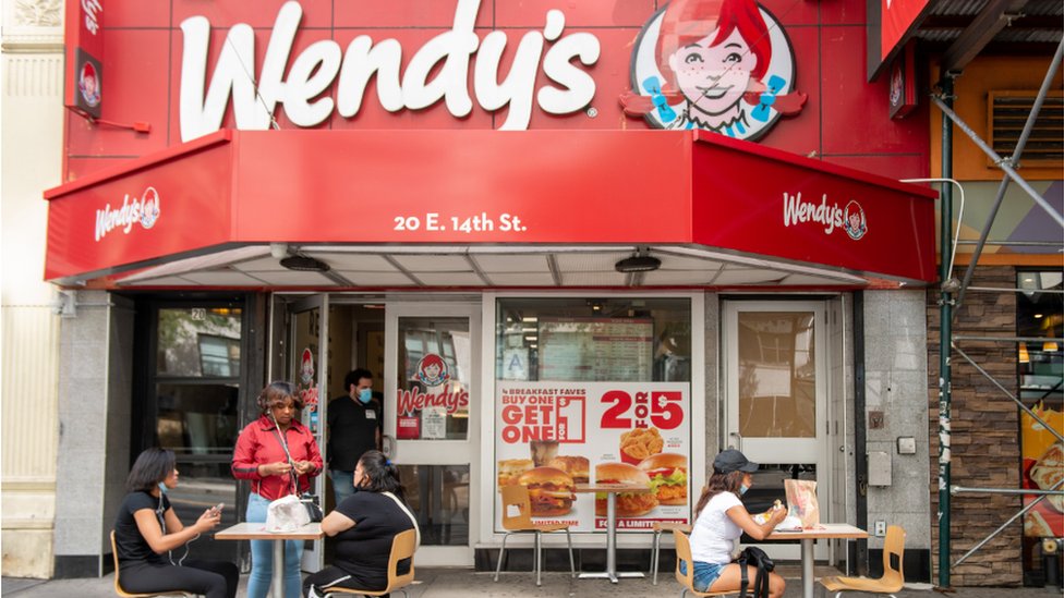 A Wendy's outlet with outdoor seating for customers.