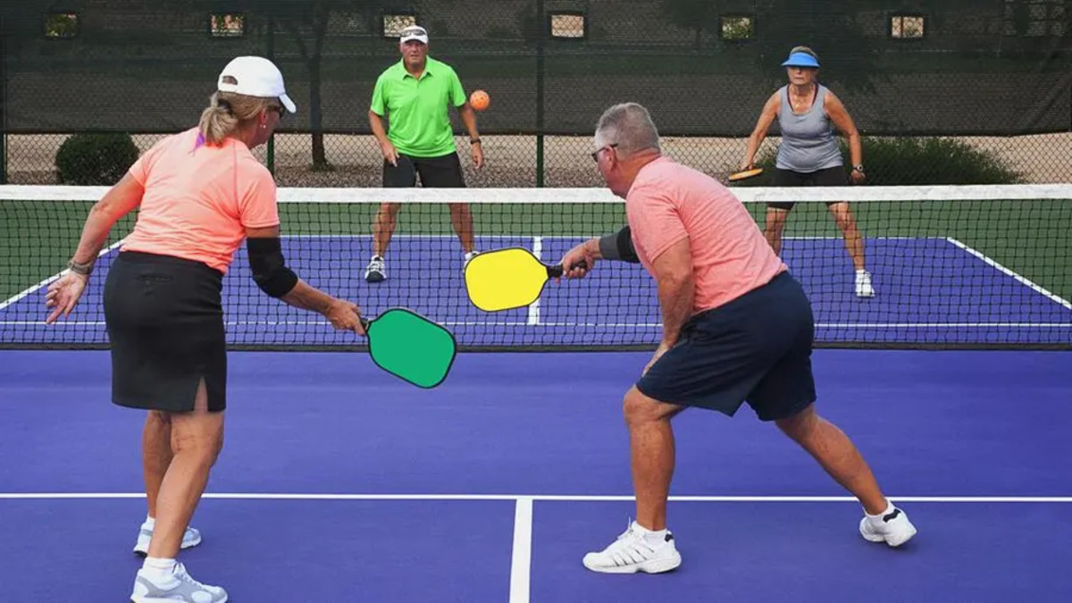 A group of senior citizens enjoying a game of pickleball on a sunny day. 