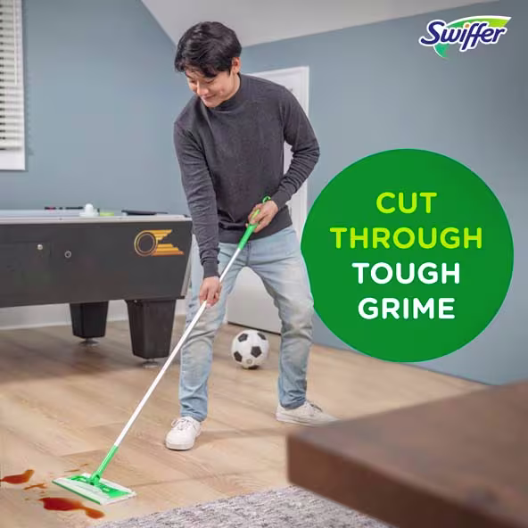 A person using a Swiffer to clean a hardwood floor, showcasing its effectiveness on tough grime in a home setting