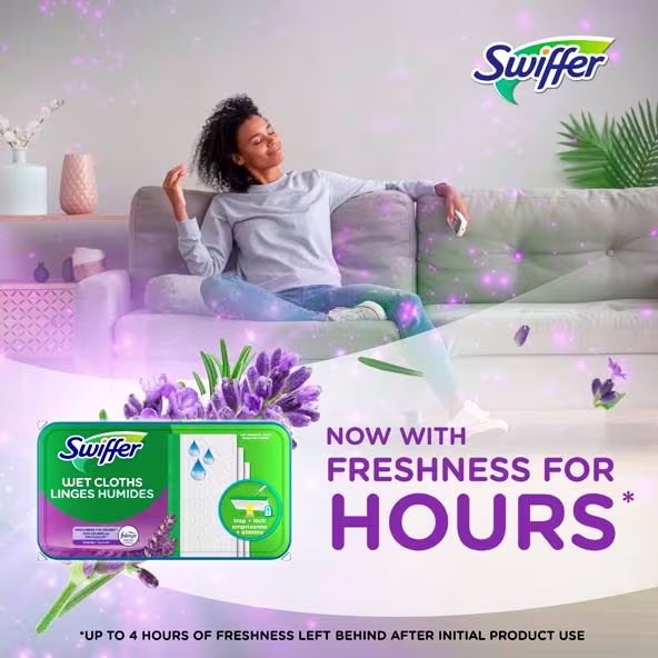 A woman relaxes on a couch, enjoying the scent of Swiffer Wet Cloths with lavender essence while promoting freshness