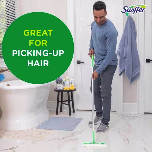 Person using a Swiffer to clean a bathroom floor, emphasizing its effectiveness for picking up hair