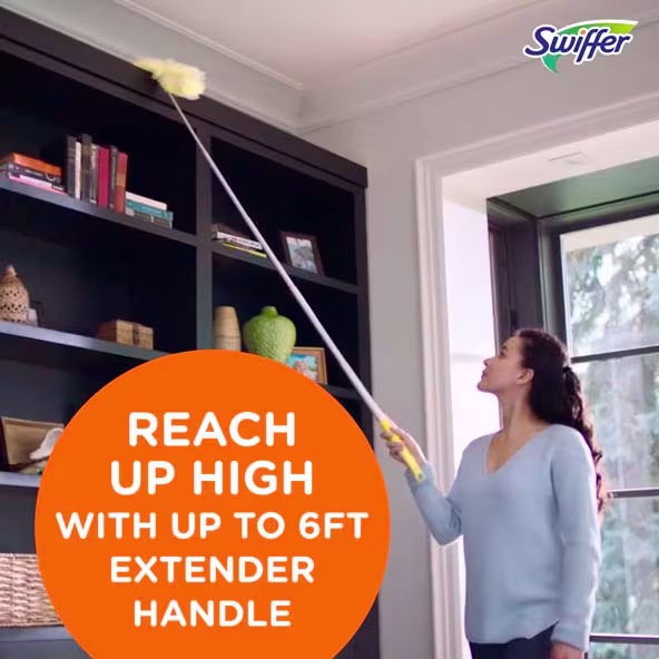 Woman using a Swiffer duster with a 6ft extender handle to clean high shelves in a bright living room