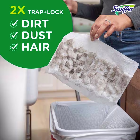 Person disposing of a Swiffer cleaning pad filled with dirt, dust, and hair into a trash bin in a home setting