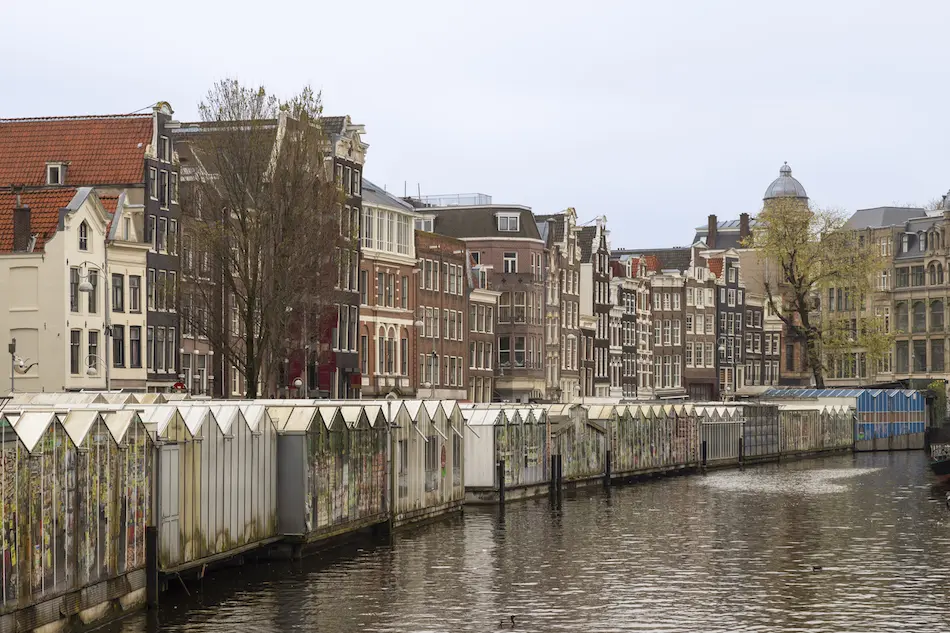 Barges float on canal in front of historic houses