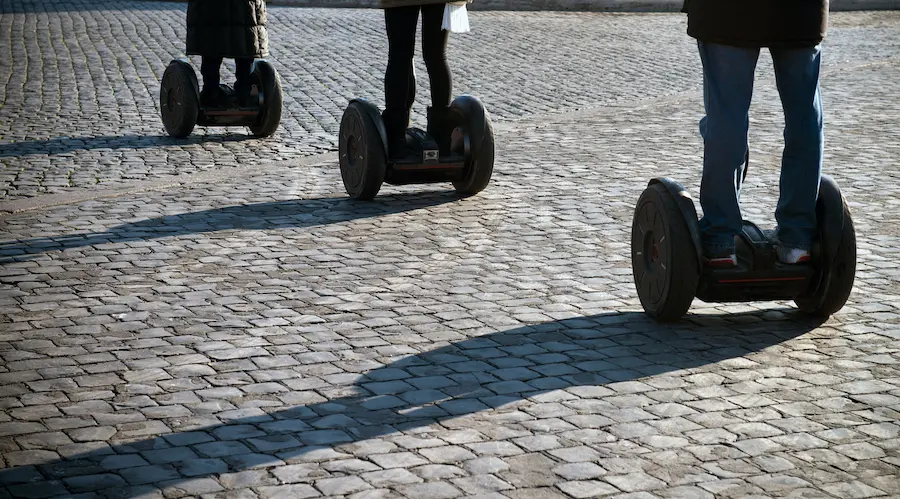 Three people ride Segways