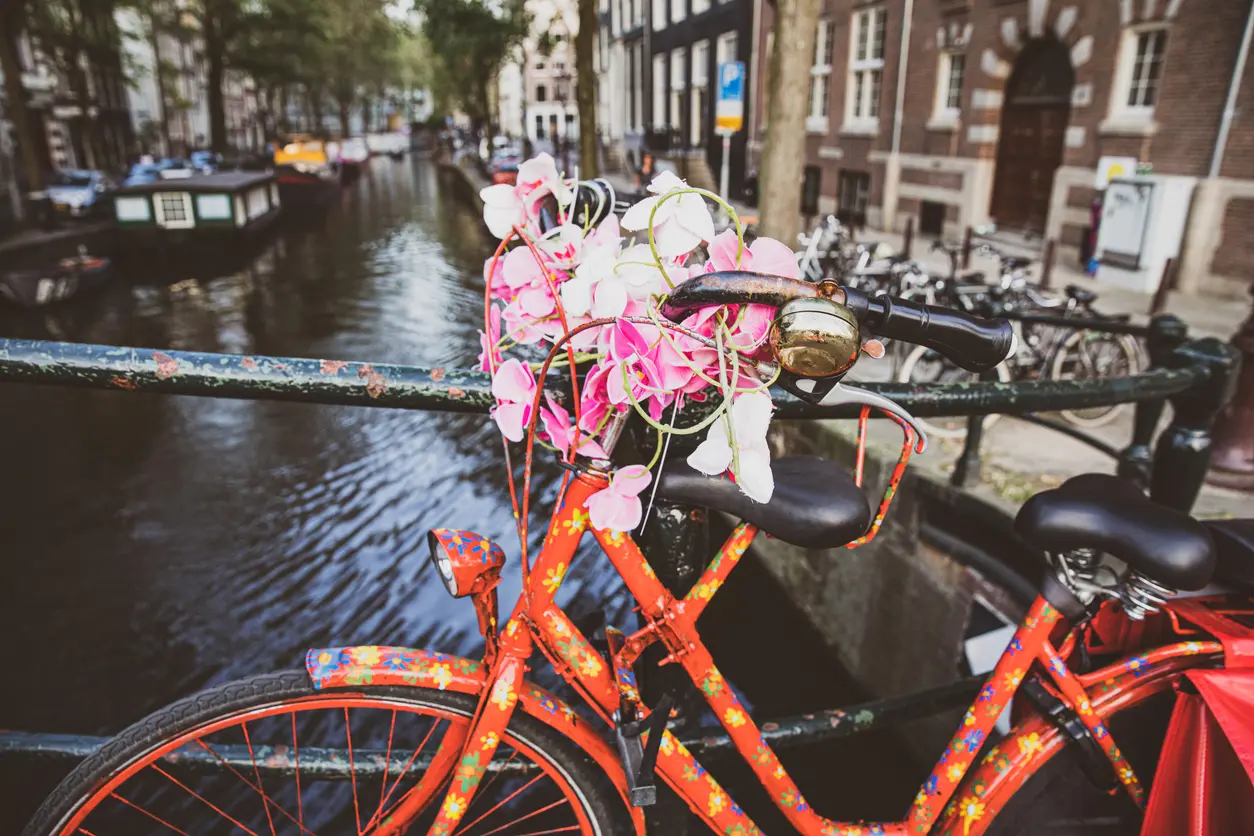 Bicycle with flowers on bridge over canal