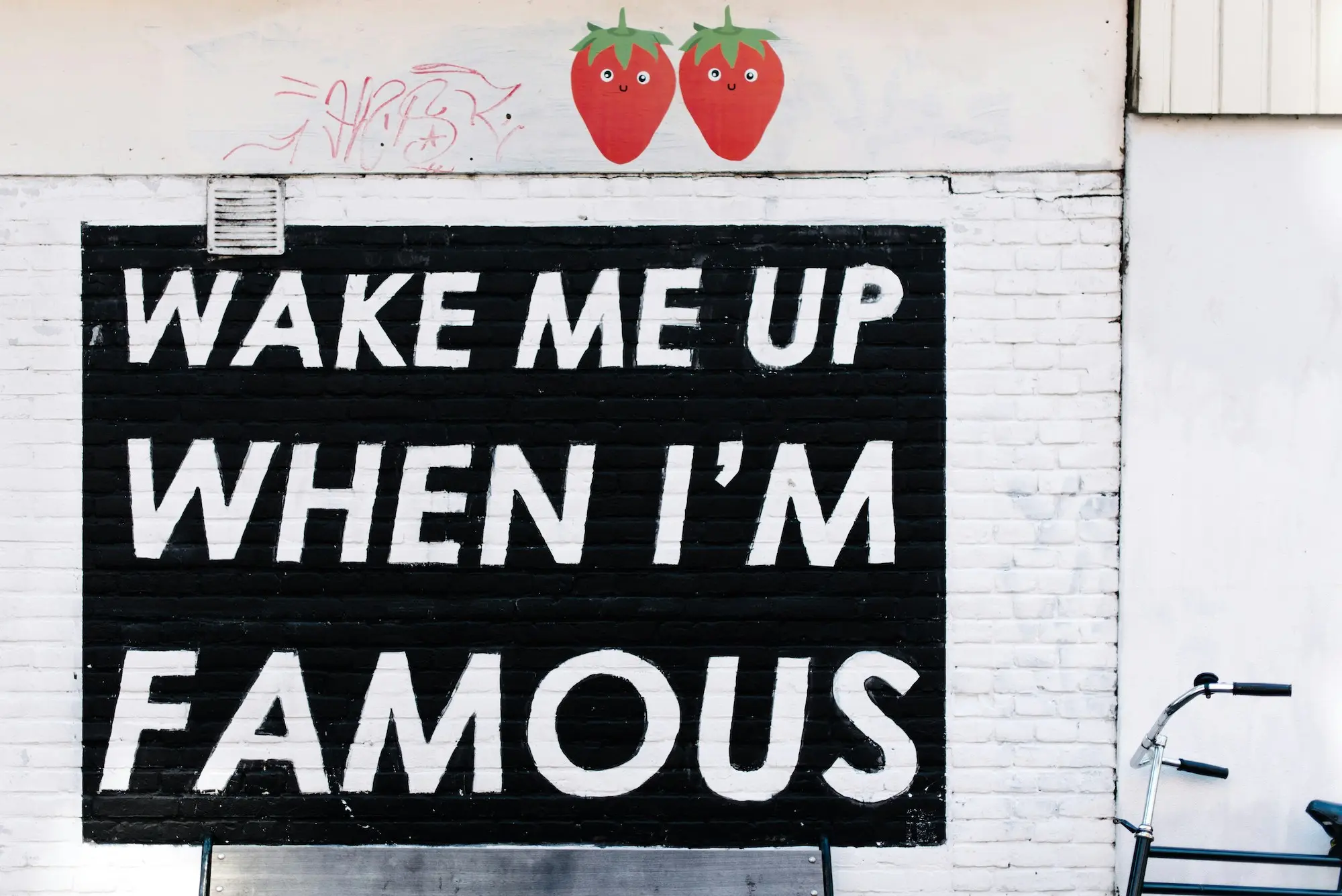 Street mural reading "Wake me up when I'm famous"