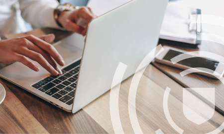 person typing on laptop with transparent shield icon and line pattern