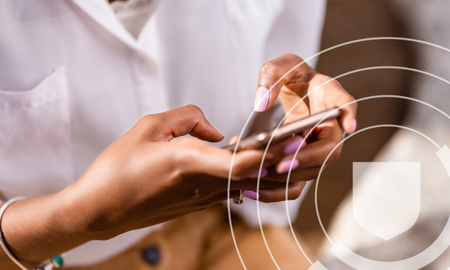 Person using a smartphone, with a shield icon overlay on the image.