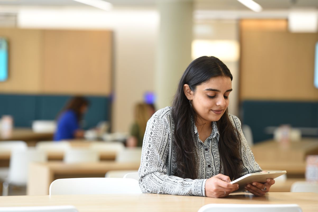 A person working on a tablet in a library