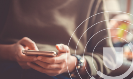 Person sitting and using a smartphone, with a shield icon overlay on the image.