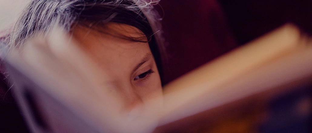 Young girl concentrated on reading her book.