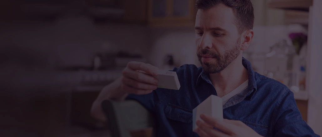  Man looking down and reading prescription label