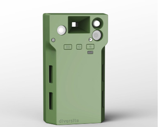 A green, rectangular electronic device with a camera lens, square viewfinder, two circular features, and three buttons on the front. The design includes ventilation slots on the sides and the word diversita at the bottom.