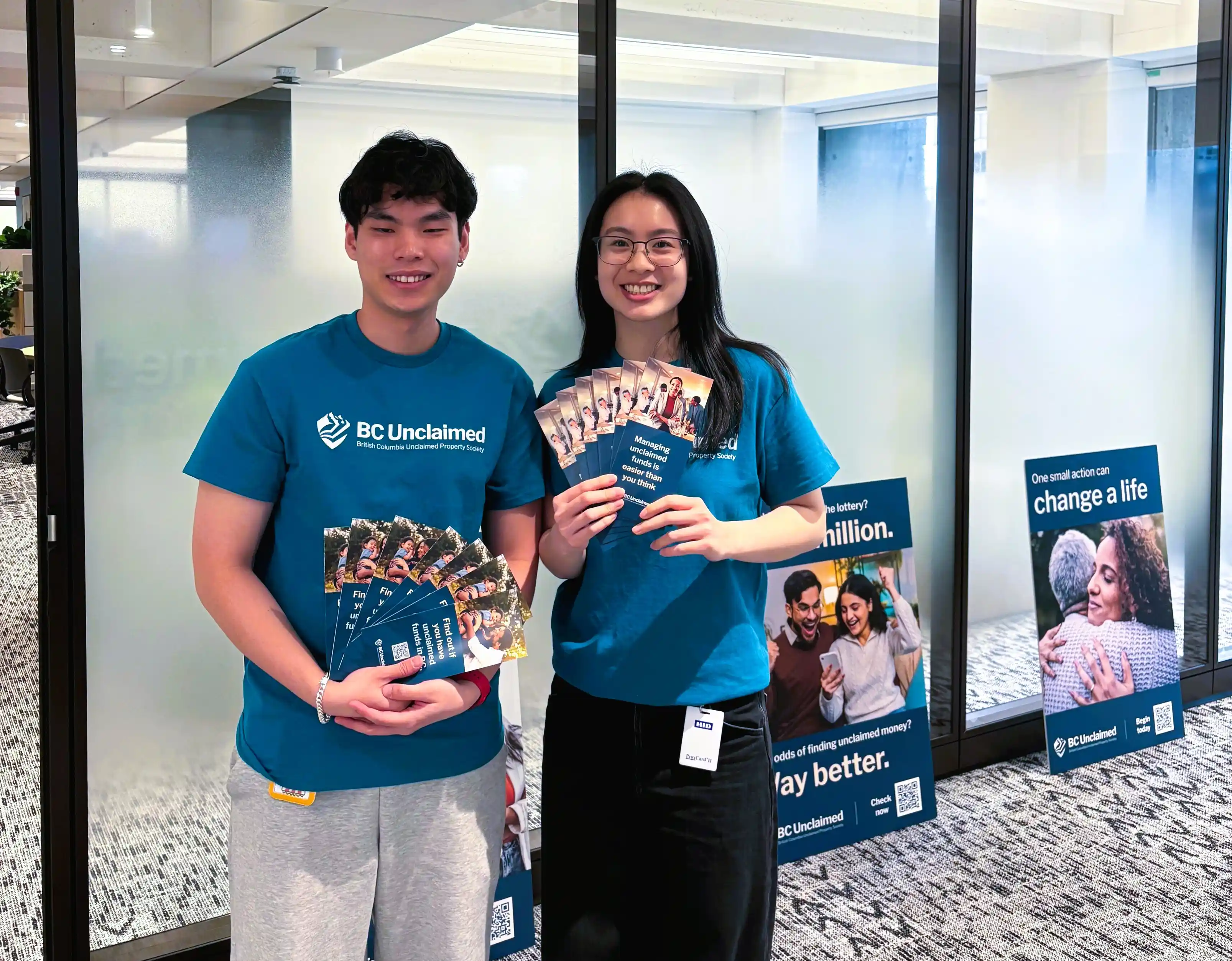 Terry and Jessica, two specialists, hold brochures at BC Unclaimed 