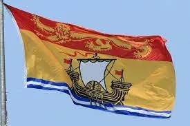 The flag of New Brunswick, which features a gold lion on red, and a ship on a yellow background, is flown