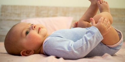 A baby is lying on his back