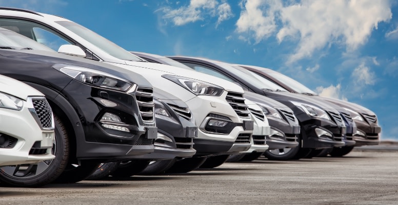 Black, white and grey cars parked parallel to one another