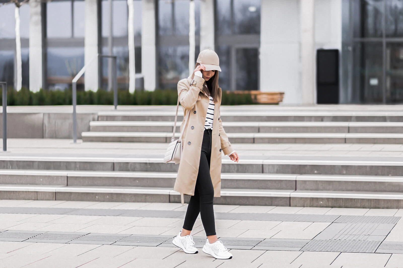 Enge Jeans Trend, Übergangsoutfit mit schwarzer Skinny Jeans und Trenchcoat, weiße Sneaker, Shoelove by Deichmann