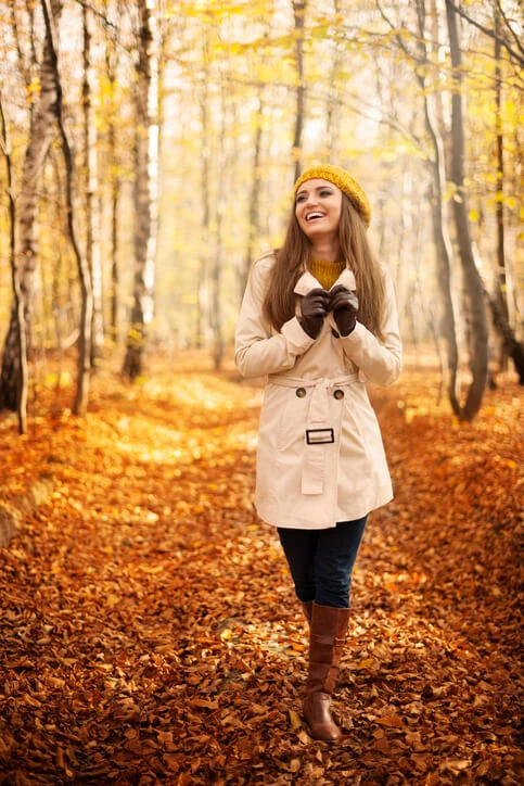 Smiling woman walking in park at autumn season