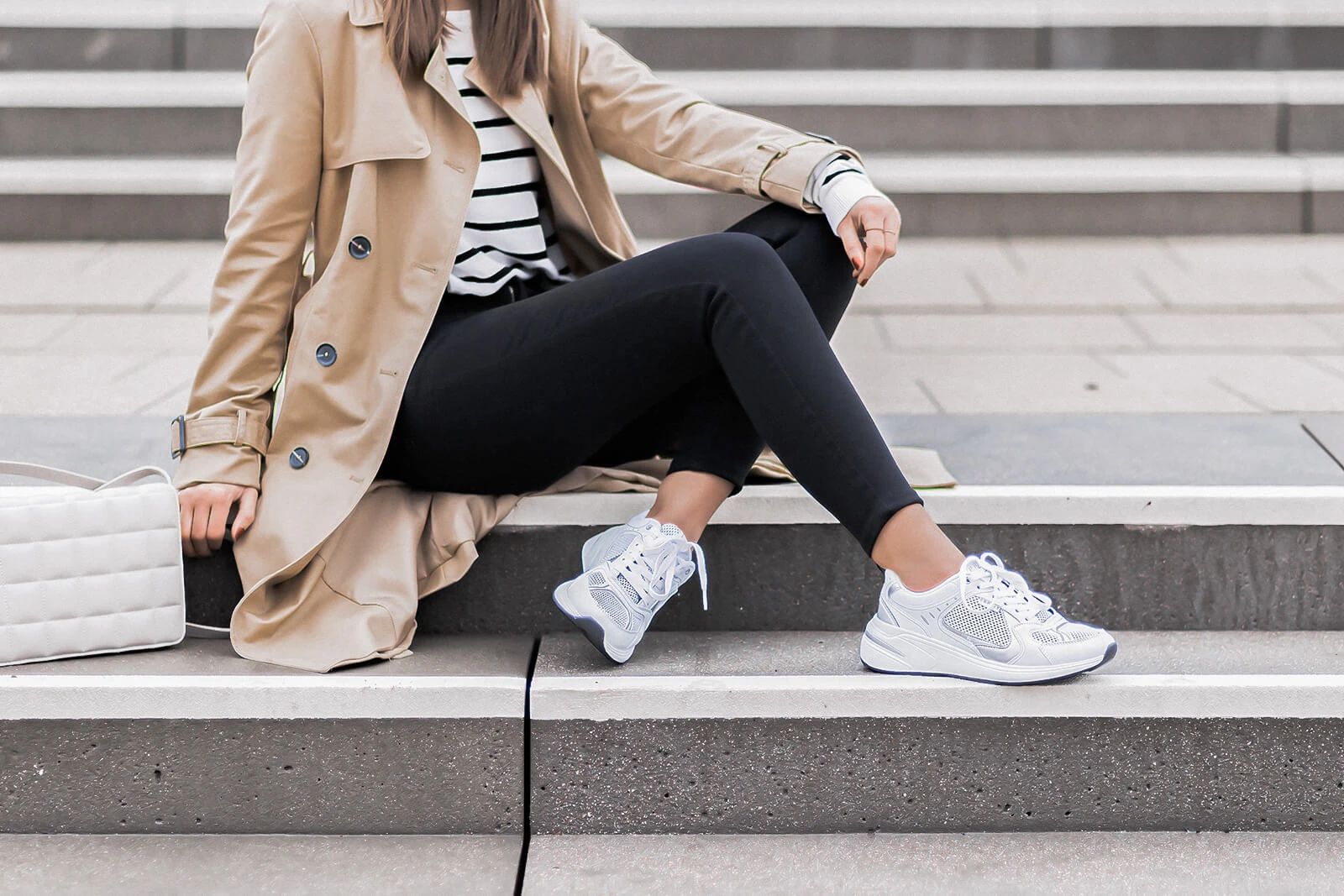 Enge Jeans Trend, Übergangsoutfit mit schwarzer Skinny Jeans und Trenchcoat, weiße Sneaker, Shoelove by Deichmann