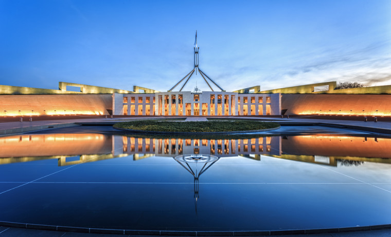 Dramatic evening sky over Parliament House in Canberra, illuminated at twilight.