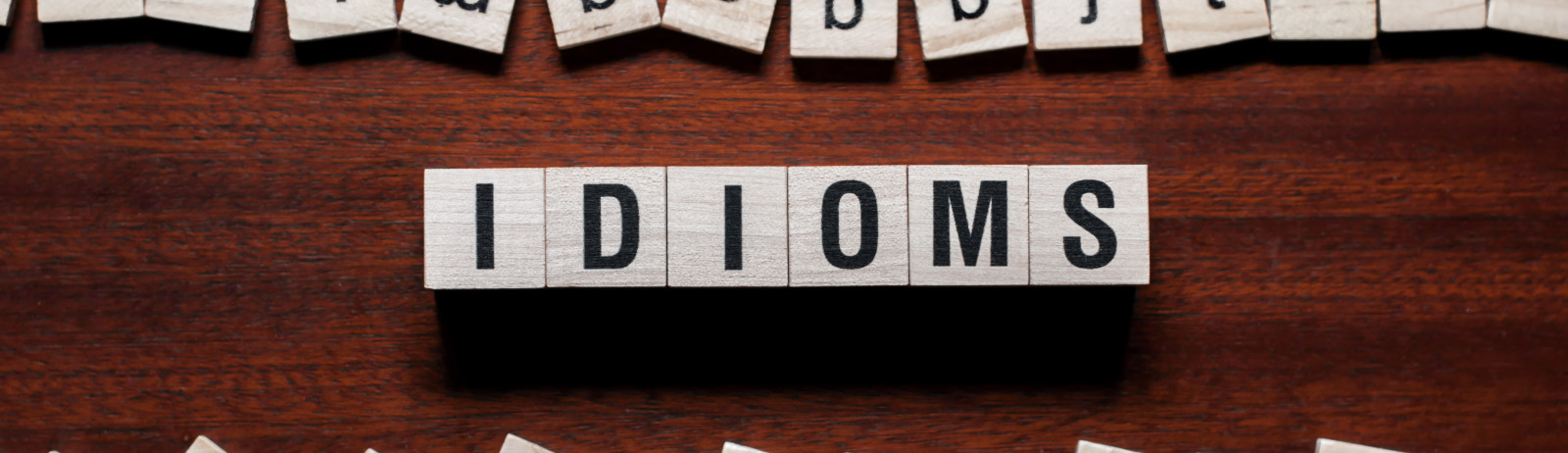 The word "idiom" spelled on wooden cubes.