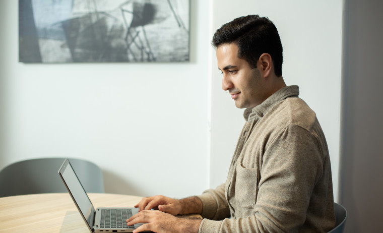 A male test taker taking IELTS test using his laptop at home