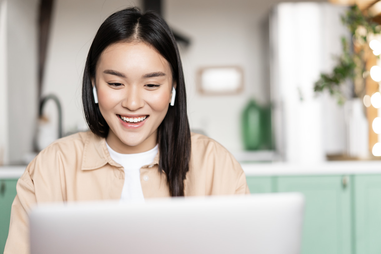 smiling-asian-girl-listening-watching-laptop-looking-computer-during-online-webinar-concept