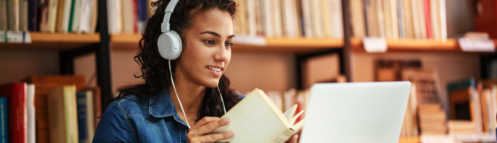 Female IELTS test taker listening to an audio clip during an IELTS on computer session