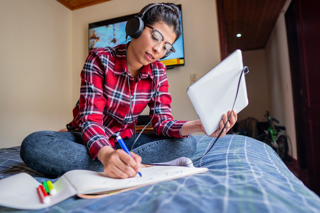 A female IELTS test taker taking notes.