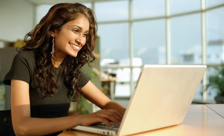 A female test taker wearing black t-shirt with spectacles and prepares for IELTS on her laptop