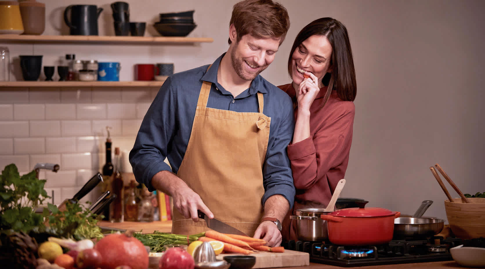 Glückliches Paar kocht zu Hause mit Gasherd
