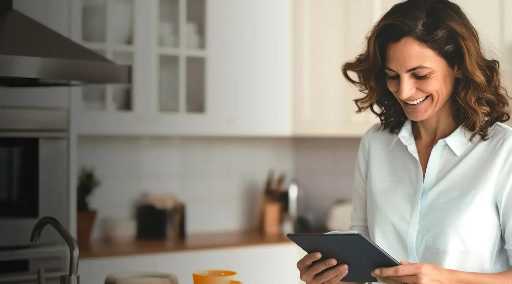 Lächelnde Frau mit Tablet in der Küche