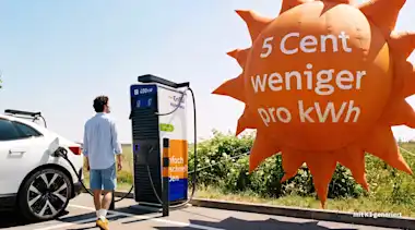 Ein Mann lädt sein E-Auto an einer EnBW-Ladesäule, rechts neben ihm fliegt ein Luftballon in Form einer Sonne mit der Aufschrift "5 Cent weniger pro kWh"