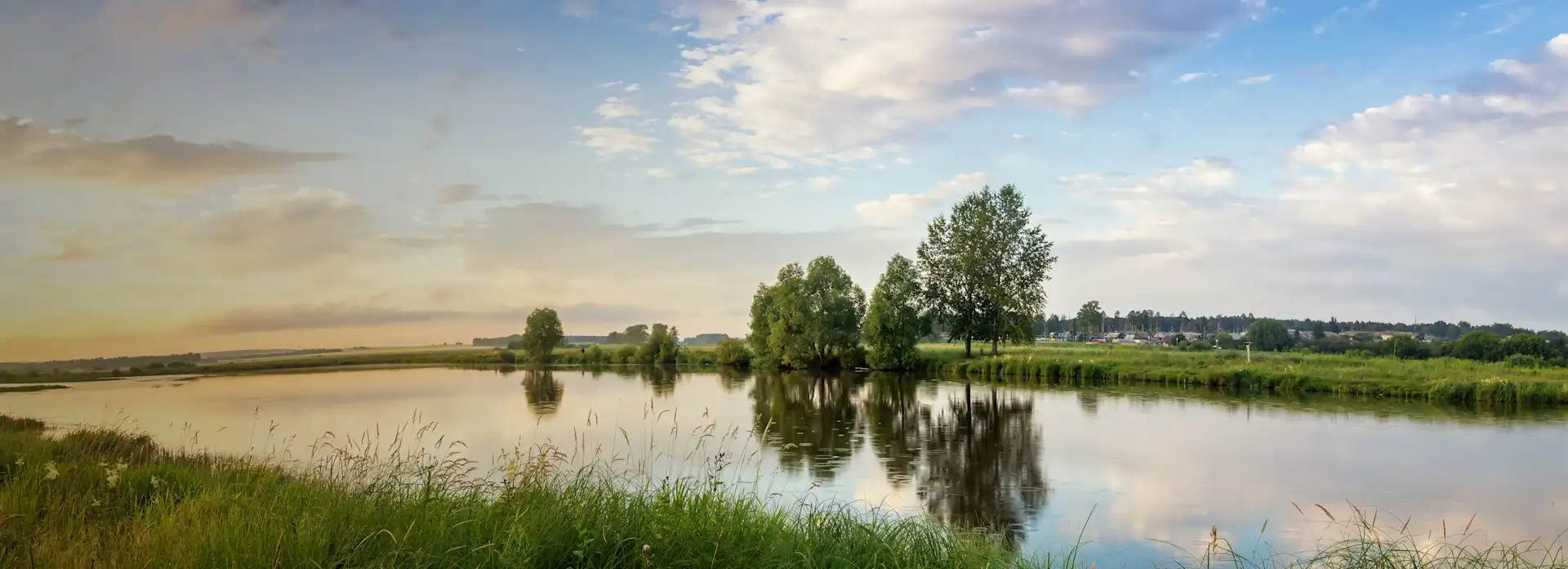 See mitten in einer grünen Landschaft bei Dämmerung