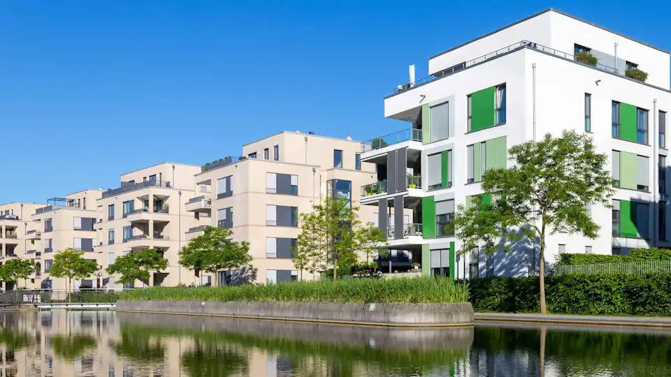 Eine Wohngegend mit modernen und neu gebauten Hochhäusern direkt an einem See/Fluss