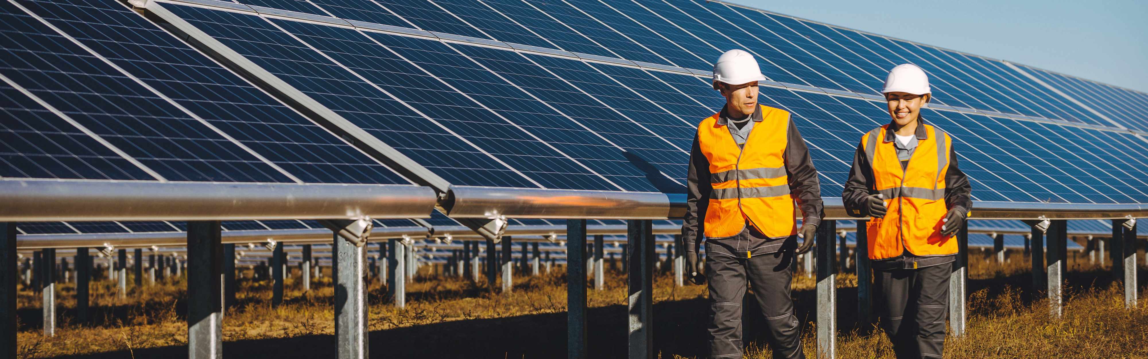 Techniker und Technikerin vor einer Photovoltaik-Anlage