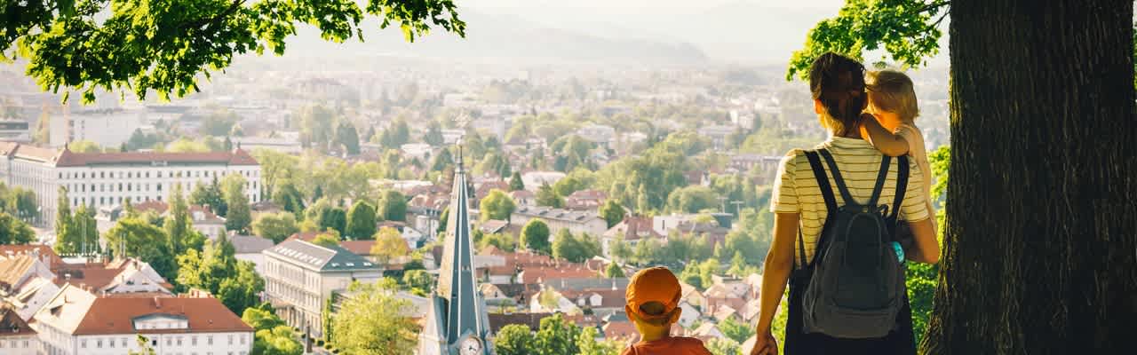 Frau mit Kindern blickt auf Kommune