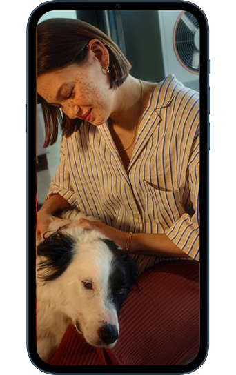 Smartphone mit Wärmestrom-Icon und Frau mit Hund