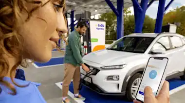 Junges Paar lädt E-Auto an einer EnBW Schnellladestation