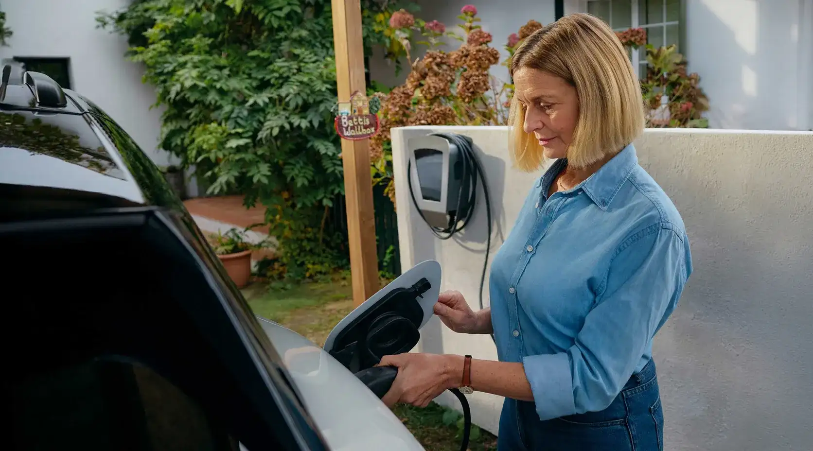 EnBW Frau Auto Laden Zuhause Elektromobilität Garten