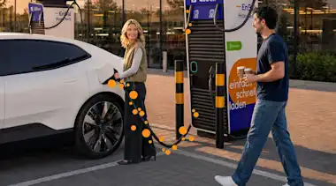 KI-generiert: Pärchen lädt an einer EnBW Ladesäule.