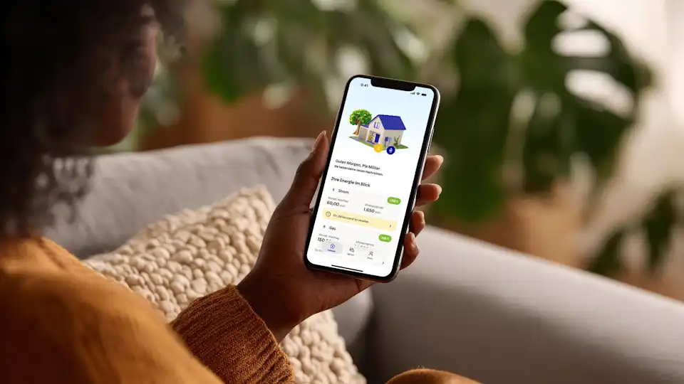 Frau hält Smartphone in der Hand mit der Startseite der EnBW Energiewelt App