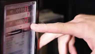 Hand am Stromzähler